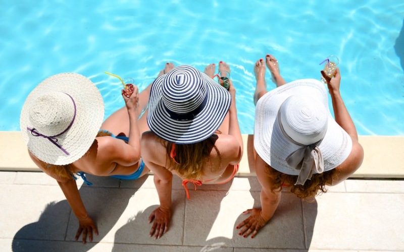 Three women sitting by the pool